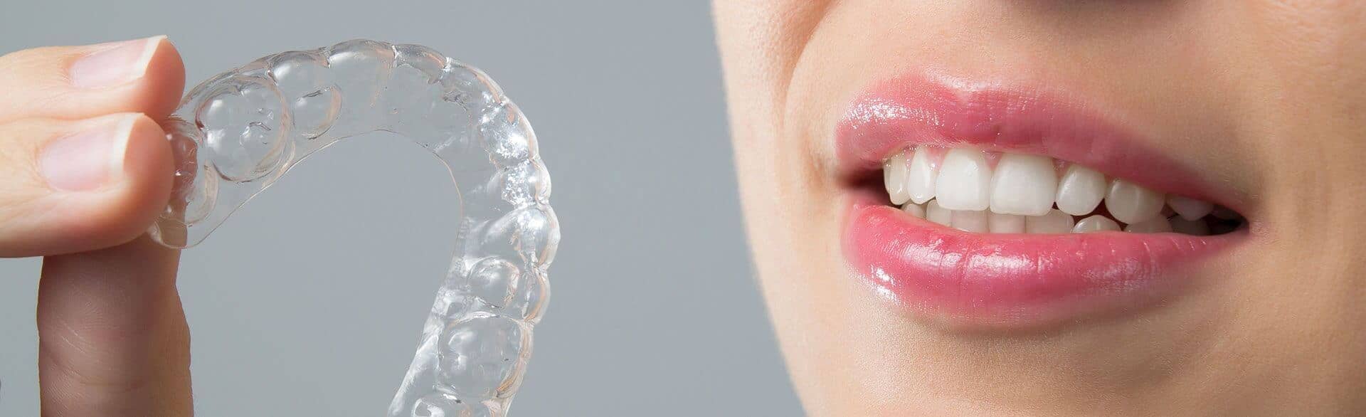 closeup of a person holding a clear aligner