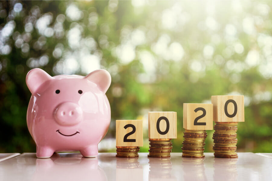 Pink piggy bank next to 2020 and coins to encourage patients to use their dental insurance benefits for 2020