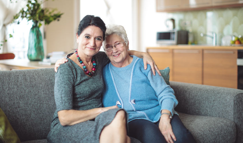 Middle aged woman and grandma sitting on couch