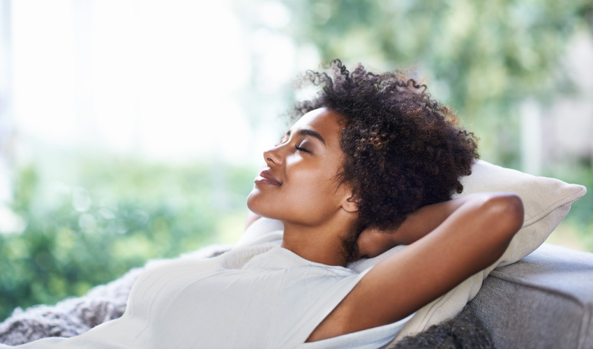 Curly-haired woman relaxes after receiving dental sedation