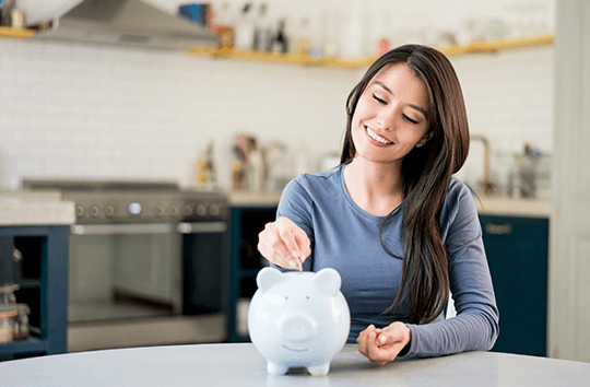 woman putting money in a piggy bank